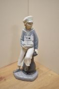 A Lladro porcelain figure boy with pond yacht, printed marks to underside 23cm