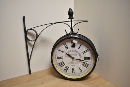 A reproduction Kensington Station clock with integral bracket, having Roman hours, 26cm diameter