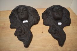 A pair of decorative cast-iron wall pockets, of Art Nouveau style and formed as female masks with
