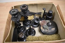 An ebony/ebonised part dressing table set including two brushes, shoe horn, perfume bottle etc.