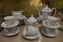 A vintage Japanese coffee set having gilted bamboo designs to white porcelain, comprising twenty
