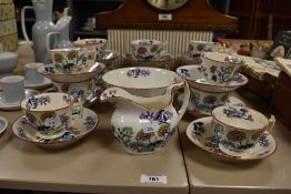 A vintage white porcelain part tea set having bright floral design and red glazing to the rim,