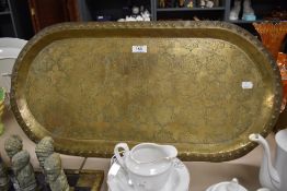 A vintage eastern brass oval tray with decorative engraving to inside.