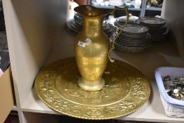 A brass plaque depicting a pub scene sold alongside a large jug/wine vessel.