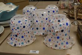 A selection of early 20th Century milk glass light shades with polka dot decoration, each