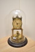 An early to mid 20th century brass 400 day torsion anniversary clock, under glass dome, having