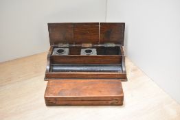 An oak desk tidy with inkwells and mahogany pencil case