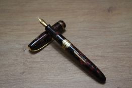 A Burnham No55 lever fill fountain pen in red marble with two narrow bands to the cap having Burnhan
