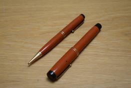 A Parker Duofold Special button fill fountain pen and propelling pencil in red with two bands to the