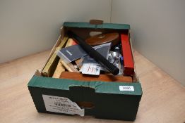 A box of various wooden pencil cases, rules, measures, jewellers loupes and a Halo LED light