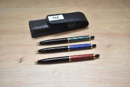 Two Pelikan ballpoint pens in green and red and a Pelikan propelling pencil in blue