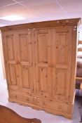 A modern pine double wardrobe, having drawer base, dimensions approx, W180 H204 D60cm