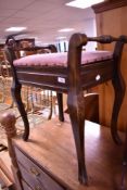 An early 20th Century piano stool on cabriole legs
