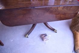 A 19th Century Regency mahogany breakfast table having drop flaps, turned column and quadruple splay