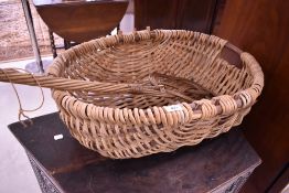 A vintage wicker swill basket and carpet beater