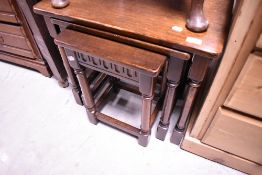 A dark oak nest of three Ercol or Priory style occasional tables
