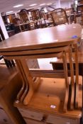 A vintage teak effect laminated nest of three occasional tables
