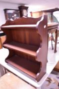 A modern mahogany effect wall shelf, width approx. 56cm
