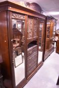 A Victorian mahogany armoire wardobe , with central cupboard section having applique decoration to