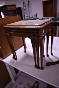 A reproduction nest of three mahogany tables