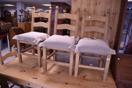 A natural pine kitchen dining table and set of four similar ladder back dining chairs, table approx.