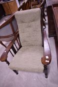 An early 20th Century oak framed recliner chair having later upholstery
