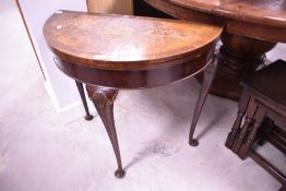 A mid 20th Century walnut fold over card table (veneer badly water damaged)