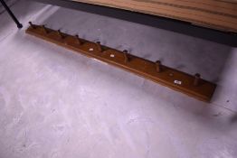 A stained pine coat rail, width approx. 163cm