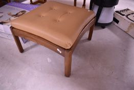 An Ercol footstool with beige leather upholstery
