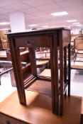 An early 20th Century mahogany nest of three occasional tables, the smallest table having frieze