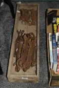 A selection of vintage tools including spanners within a rectangular rustic tray