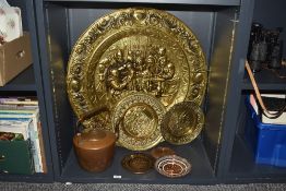 A large embossed brass decorative plaque, two smaller examples, small continental copper plates,