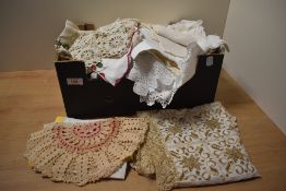 A box of assorted laced worked items, including table cloths