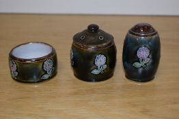 A Royal Doulton stoneware three piece condiment set, comprising salt, mustard and pepperette, each