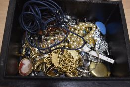 A wooden jewellery box containing a small assortment of costume jewellery, including brooches,