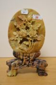 A decorative Chinese soapstone carving, of oval form and carved in relief with a bird and blossoming