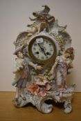 A Sitzendorf or Thuringia porcelain figural mantel clock, the dial with Arabic hours, flanked and