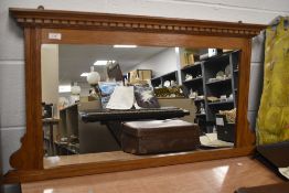 A 20th Century stained oak overmantle mirror, the moulded plinth above a dentil cornice, measuring