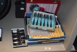An assortment of vintage cutlery (mostly boxed) comprising cake forks, dessert spoons, corn on the