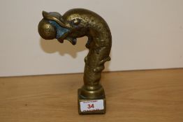 An unusual heavy cast-brass 'dolphin' head of 19th century design and modelled ball in it's mouth,