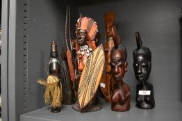 An African carved hardwood study of a warrior with weapons and shield, measuring 32cm high, together