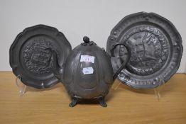 Two reproduction pewter dishes, each embossed with armorial detail and sold together with a pewter