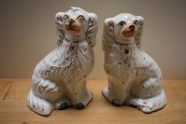 A pair of Victorian Staffordshire pottery dogs, the detail heightened with gilding and each