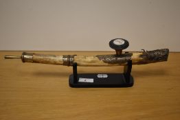 An interesting and decorative Chinese white metal-mounted opium pipe, the head with Dragons head