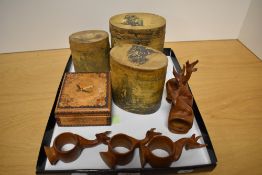 A group of six African carved wood antelope form napkin rings, three graduating oval lidded boxes of