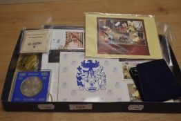 A box of commemorative crowns, postcards, and stamps