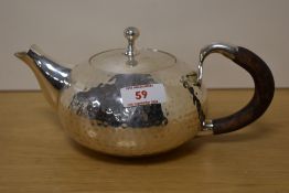 An attractive silver-plated teapot, of compressed and planished globular form with screw-off