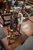 A relatively modern wooden spinning wheel, of traditional design with foot operated mechanism 93cm