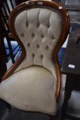 A reproduction spoon back nursing chair, the deep buttoned back over the sprung seat and moulded