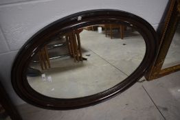 A mahogany oval frame wall mirror, approx. 86 x 63cm